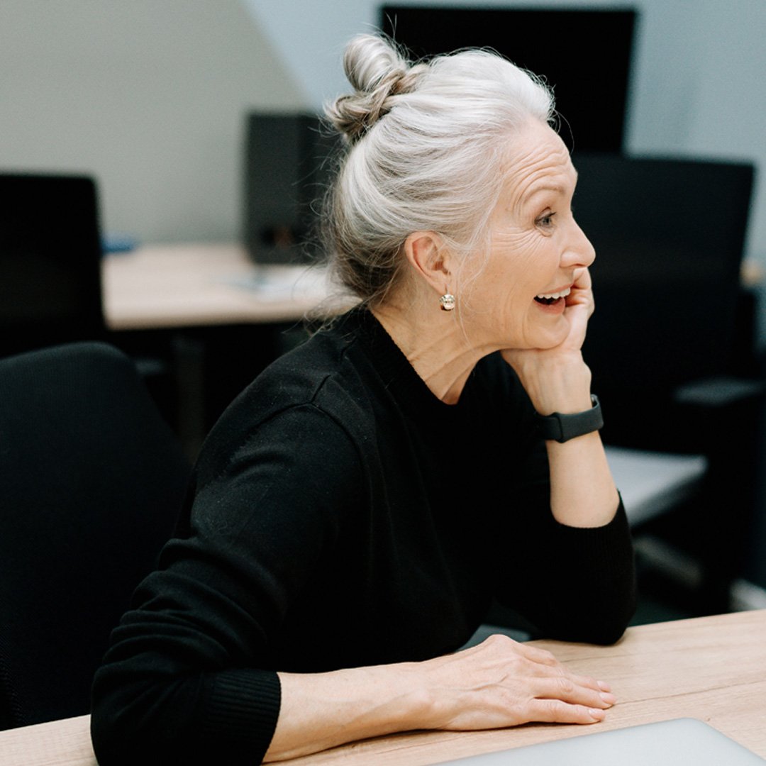 Woman sitting and smiling at desk